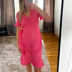 klänning - Jättefin och söt klänning med volanger och knytning från vero moda i storlek xs! I jättebra skick och använd ett fåtal gånger🩷