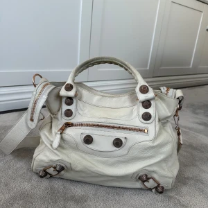 Balenciaga Velo Tote  - Cremevit Giant Balenciaga Velo väska med rosegold hardware. Visst slitage/fläckar finns, se bilderna.  Kommer med dustbag.   Mått: B: ca 30 cm H: ca 30 cm
