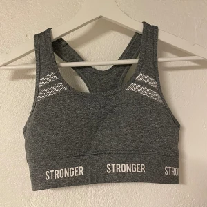Sport-bh från Stronger  - Markeringarna i ryggen saknas där storlek står osv, annars fint skick! De synliga trycken sitter bra och är hela 🌟