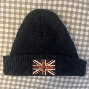 Henri Lloyd mössa - Blå mössa med brittiska flaggan från Henri Lloyd. Köpt på Care of Carl. Bra vid kallt väder. 
