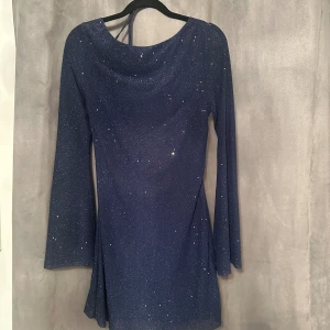 Glittrig klänning - Glittrig klänning med öppen rygg