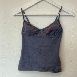 Linne med kupor  - Grått/blått linne med kupor och byglar. Orange detaljer på kuporna och detaljerad rygg med snörning/band.  Ser lite sportig ut. Står ingen storlek men skulle säga att den passar xs-s och att kuporna är ganska små: A/B. Defekter på sista bilderna.