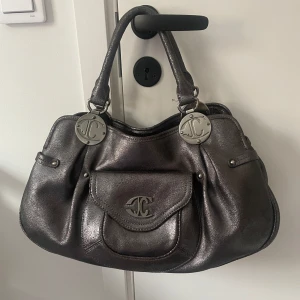 Just cavalli väska - Jättesnygg silvrig väska från Just Cavalli! Säljer för den kommer inte till användning tyvärr!