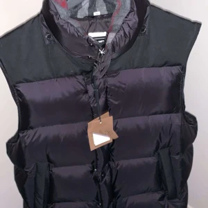 Burberry jacka/väst - Använd typ 2 gånger, det är en vinter jacka som kan omvandlas till en väst vilket är perfekt nu till sommaren, storlek L, färg svart.