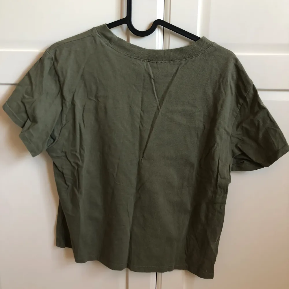 En grön t-shirt med vitt tryck. Tröjan är knappt använd, är i bra skick och säljs billigt. Passar även mig som har S. . T-shirts.