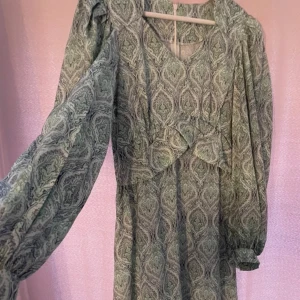 Grön klänning - Helt ny aldrig använd. Dragkedja där bak! Går nästan ner till ankeln lite över. Den är lång men inte maxi