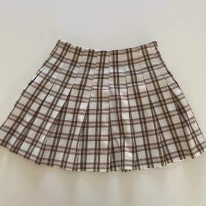 Bra skick, använd fåtal gånger 🫶 Vit / ljusbeige & brun - plisserad! En kort kjol som är perfekt till sommaren, har dragskjedja och knapp i vänster sida. 🫶