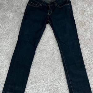 Mörkblå, raka, lågmidjade Hilfiger jeans. Skulle säga xs/s. Står W27 L34 i dem