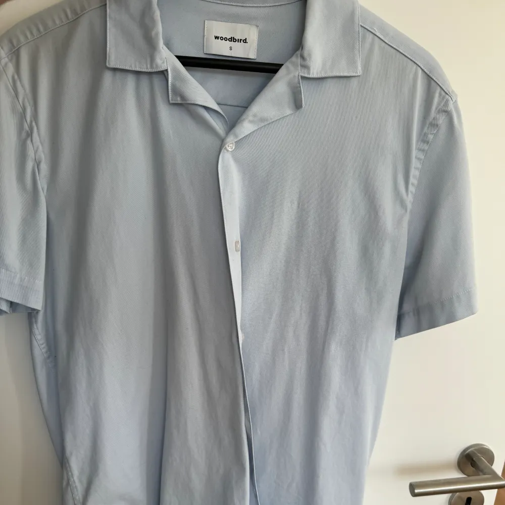 Kortärmad skjorta med bowlingkrage från woodbird. Lite smuts som syns på bild 2 i övrigt bra skick. Bör gå bort i tvätten . Skjortor.