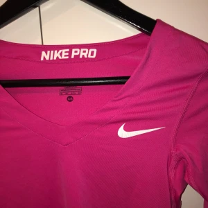 Rosa nike pro tröja - Träningströja  Den är en tight tröja  Den är xs men passar på mig som är mellan s-m