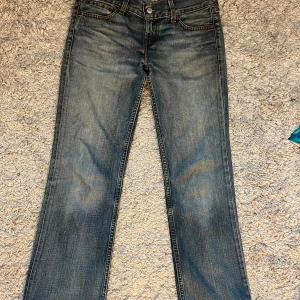 ”Eve” low levi’s jeans - Super snygga låg midjade, square-cut straight Levi’s jeans som tyvärr är för stora för mig. Jag har haft skosnören i så det är hål för det💗 Tvärsöver midjan är de 40 cm och innerbensmåttet är 73
