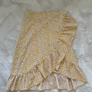 Jättefin gul kjol men ett blommigt mönster. Perfekt till sommaren! Har dragkedja och så att man kan knyta den🌼