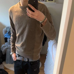 Oscar Jacobsson tröja  - Säljer min oscar jacobsson crewneck. Fint skick, inga defekter, hål eller liknande. Färgen är ljusbrun. Tröjan är i en bomull och kashmir blandning. Nypris är ca 1500 och är slutsåld överallt. Han på bilden är ca 180 cm lång. Hör av er vid intresse!🙌