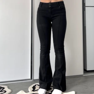 Utsvänga byxor - Utsvängda svarta byxor från pull and bear med pressväck och öppen söm nertill.  Jag är 177cm och de går hela vägen ner. Midjemåttet är 37cm så omkretsen runt midjan är ca 74cm. 