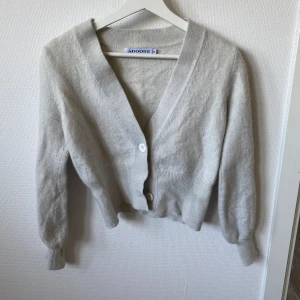 Kofta från adoore - Säljer min stickad kofta från adoore då den inte passar längre. Det har tidigare blivit lite krympt i tvätten. Stolek 38 men passar nu kanske en 34/36. Färgen är krämvit, bilden är lite missvisande. Nypris 1199kr. Säljer för 300kr