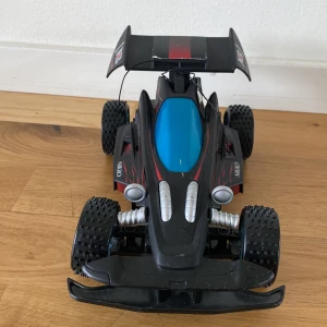  Radiostyrd bil. -  Den här bil kan åka på väldigt många olika saker tack vare taggarna på däcken. Men man måste vara runt 3 m ifrån bilen annars slutar den köra. Man kan köpa till en antenn Så att man kan stå längre bort från bilen.