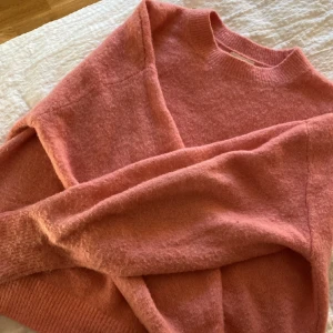 Rosa stickad tröja - Jättefin rosa stickad tröja från hm. Den är lite ljusare i verkligheten än på bild. Bredare armar som sedan smalnar av vid handleden vilket jag tycker är jättefint.💗