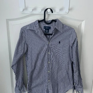 Ralph lauren skjorta  - Nyskick använd typ 3 gånger! Riktigt go skjorta att ha under en tröja nu på våren! Hör av er om ni undrar något! Storlek S Köpt ny för 1300 från careofcarl