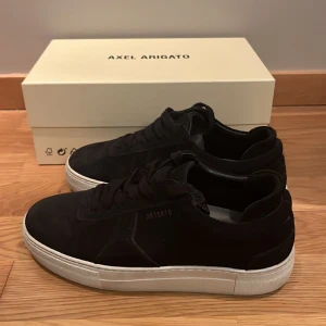 Arigato skor - Säljer ett par svarta Axel Arigato skor EU37. Perfekt till somaren. Bra skick. Nypris 2500kr
