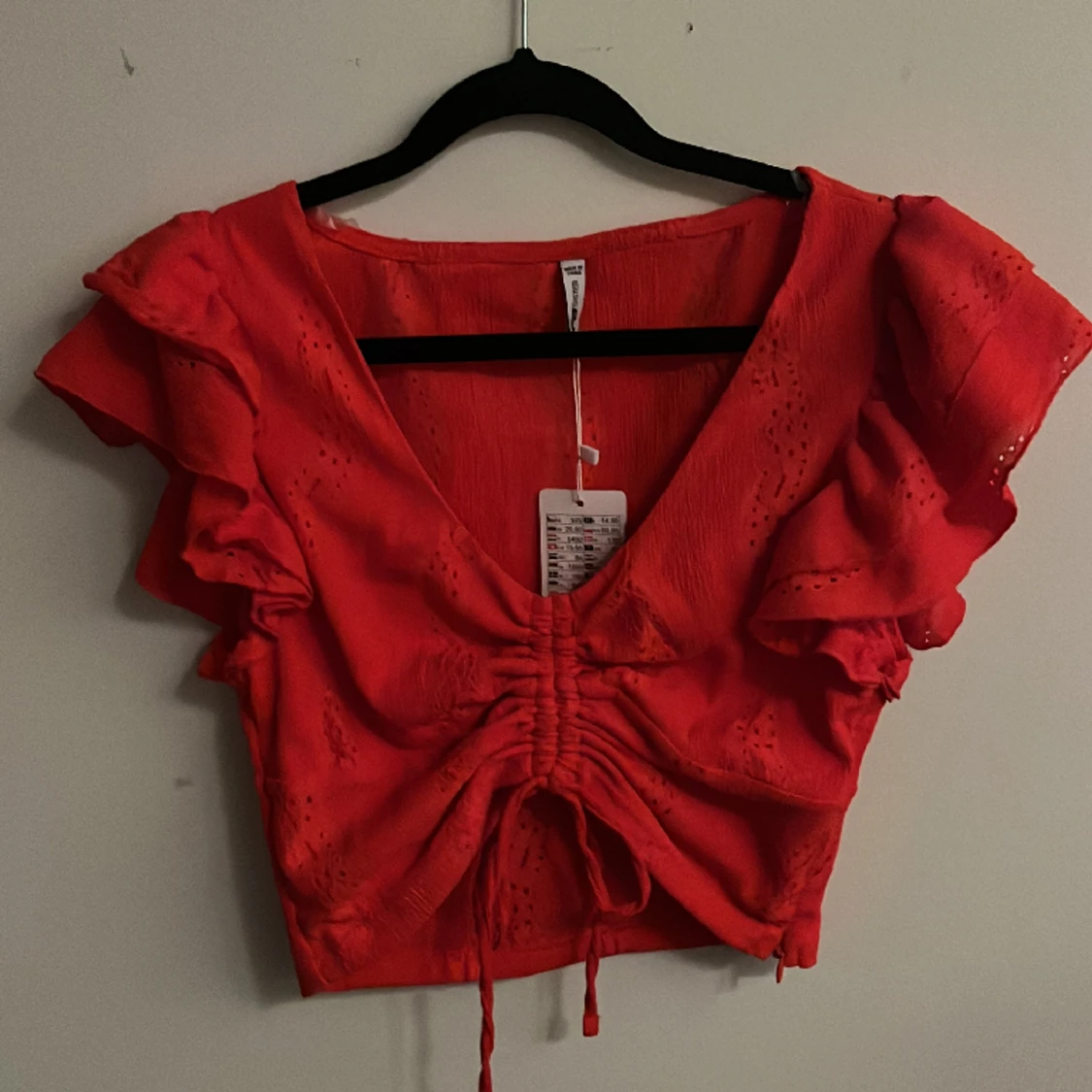 Fin röd kroppad top med snörning och volang, stl S