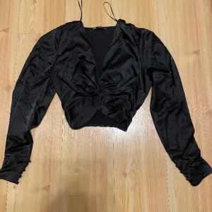 Satin fintröja - Svart blus i silke med knytdetalj framtill. Ej använd. 220kr + frakt.