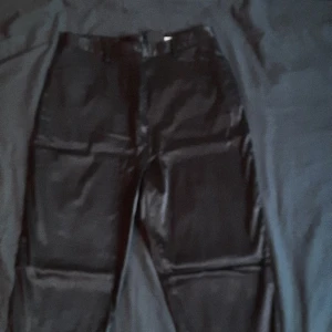 Silkesliknande svarta byxor - Svarta högmidjade tajta byxor i silkesliknande tyg! Asballa från morsans goth fas;) Älskar dessa men de är för stora så nu får nån annan ta över... 