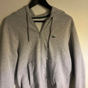 Grå Lacoste zip - Säljer min Lacoste zip då den inte passar mig. Pris kan diskuteras 