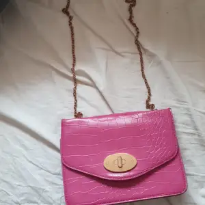 En typ mörk rosa väska som är använd 2 gånger men lite färg som är borta.