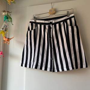 Randig kjol från Monki med knappar fram. Den har fickor. Storlek 42. Oanvänd med prislapp. 