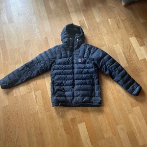 Fjällräven Dunjacka - Säljer min Fjällräven dunjacka i mycket bra skick. Ända defekten är att högra jackfickans blixlås krånglar, i övrigt inga hål eller liknande.  Köpte den för ca 4000 kr.