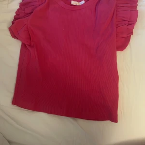 Rosa volang topp  - Hej! Nu säljer jag min rosa volang topp från Gina Tricot. Använd fåtal gånger. Storlek 146/152. Nypris: 180kr. Mitt pris: 90kr. Köparen betalar frakten. 