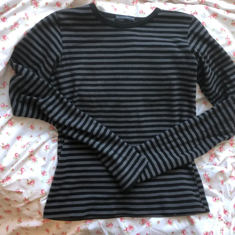 Säljer denna jättesnygga Brandy Melville tröja då jag inte gillar hur den sitter på just mig </3 Skönt och stretchigt material. Använd ett fåtal gånger och har inga synliga tecken på användning💗 Grå/Svart randig.. T-shirts.