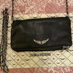 Zadig & Voltaire Rock Väska - Säljer min svarta ”normalstora” Zadig väska!! Använd men fortfarande i fint skick, endast lite rost på spännen (bild 2) och en liten ”fläck” MEN som endast ses i vissa ljus (bild 3)!! Dust bag och två kedjor (kort och lång) följer med⭐️⭐️