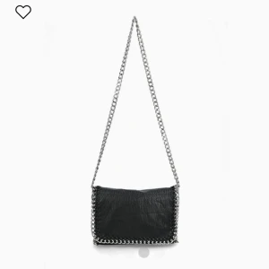 Tiamo väska - Tiamo, svart axelremsväska i skinnimitation med silverfärgad kedja. Ett fack med dragkedja på baksidan även en i insidan. Axellänk 105 cm (kan vara kortare). Längd 28 cm, höjd 18 cm, bredd 5 cm. Några slitningar på insidan, därav nedsa priset…