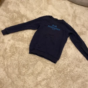Mörkblå sweater - En mörkblå sweater från peak performance med ljusblå text i mitten. 