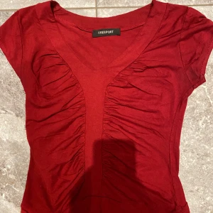 Topp/t-shirt - En jättefin illröd topp/T-shirt. Säljer pga stor garderobrensning. Kika gärna på mina andra annonser, säljer mycket. Samfraktar gärna:) 