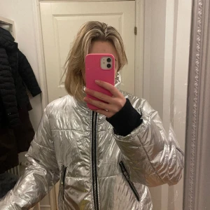 Silvrig pufferjacka - Coolaste jackan! Silvrig, varm och perfekt för skidsemestern. Älskar allt med denna. Jättebra skick, storlek L, men en liten sådan då den sitter lite oversize på mig som vanligtvis har S. 