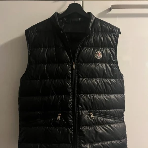 Moncler Gui - Säljer nu min moncler gui väst som är använd men fortfarande i ganska bra skick, ett litet hål på baksida axel (bild 3). Självklart  äkta. Storlek L men sitter mer som M