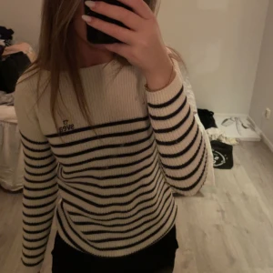 Stickad tröja  - Stickad tröja med båthals. Har en liten skada man ser på sista bilden. 