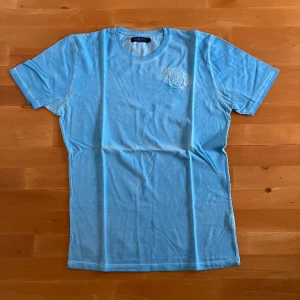 Ljusblå t-shirt - Ljusblå tvättad t-shirt från märket Hydrogen. Stl XL men sitter som M/L