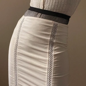 Vintage Gianni Versace Pencil Skirt - Vintage Gianni Versace Skirt with Sheer Crochet Trim Detail. Lined Skirt with back zip closure. Made in Italy. Excellent Condition.  100% Wool  Best Fits Size M  52 CM/ 20.5 IN Length 70 CM/ 27.6 IN Waist 84 CM/ 33.1 IN Hips