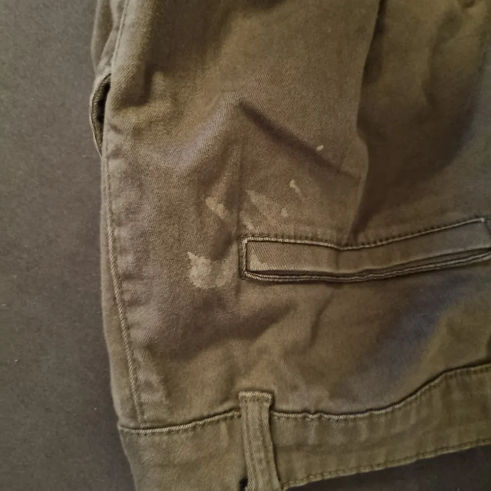 Ett par gröna cargo byxor som är lite för korta i benen. Byxorna har 1 fläck i bak vid fickan (bild 2 och 3)💖. Jeans & Byxor.