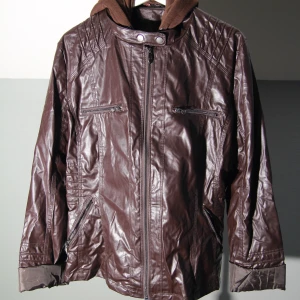 Mörkbrun läderjacka stl. 5XL - Mörkbrun läderjacka i PU-Läder Stl. 5XL Bröstbredd: 64cm Plaggländ: 67cm Bottenvid: 67cm Armlängd: 54cm  Fint skick, hel och ren