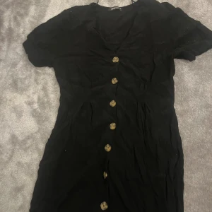 Klänning  - Säljer denna jätte gulliga svarta klänningen med knappar! Pris går att diskuteras 