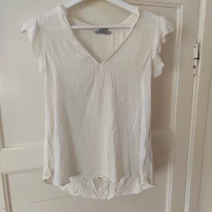 Vit topp - Mer varm vit än på bilden. Köpt för många år sedan men legat undanpackad. Mycket sparsamt använd. Supersöt!