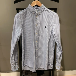 Ralph Lauren skjorta - Skit snygg skjort i topp kvalitet såljer den bliv för liten den är köpt på nk barn och är storlek 18 men det passar om du har xs.1 liten fläck! Pris kan sänkas vid snabb affär och tveka inte på att ställa frågor!