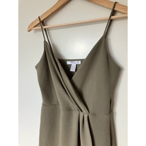 Klänning med omlottdetalj - Fin knälång festklänning med omlottdetalj fram. ⭐️ Storlek L men kan även passa M. Endast använd en gång. Djur- och rökfritt hem.