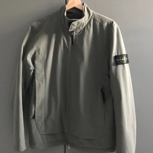 Grön vår/höstjacka från Stone Island  - En fin grön Stone Island jacka för våren eller hösten i nyskick, står emot vind och regn.