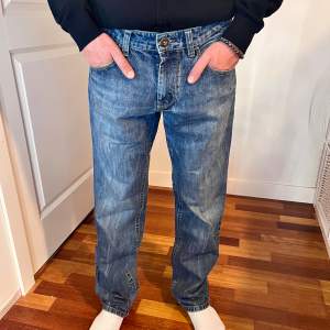 Blå jeans med rak passform i storlek 33/32. Modellen är 180.