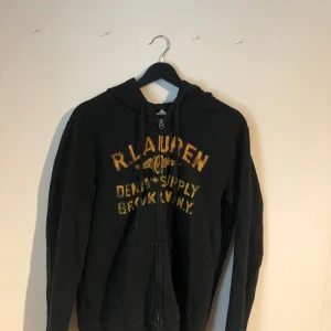 Ralph lauren zip hoodie Vintage M - Fet och unik vintage Ralph lauren - denim & supply hoodie i storlek M! Slitningarna på trycket är inte en defekt utan den är så original och skicket är ungefär 8/10. Hör av er vid frågor eller funderingar eller prisförslag!